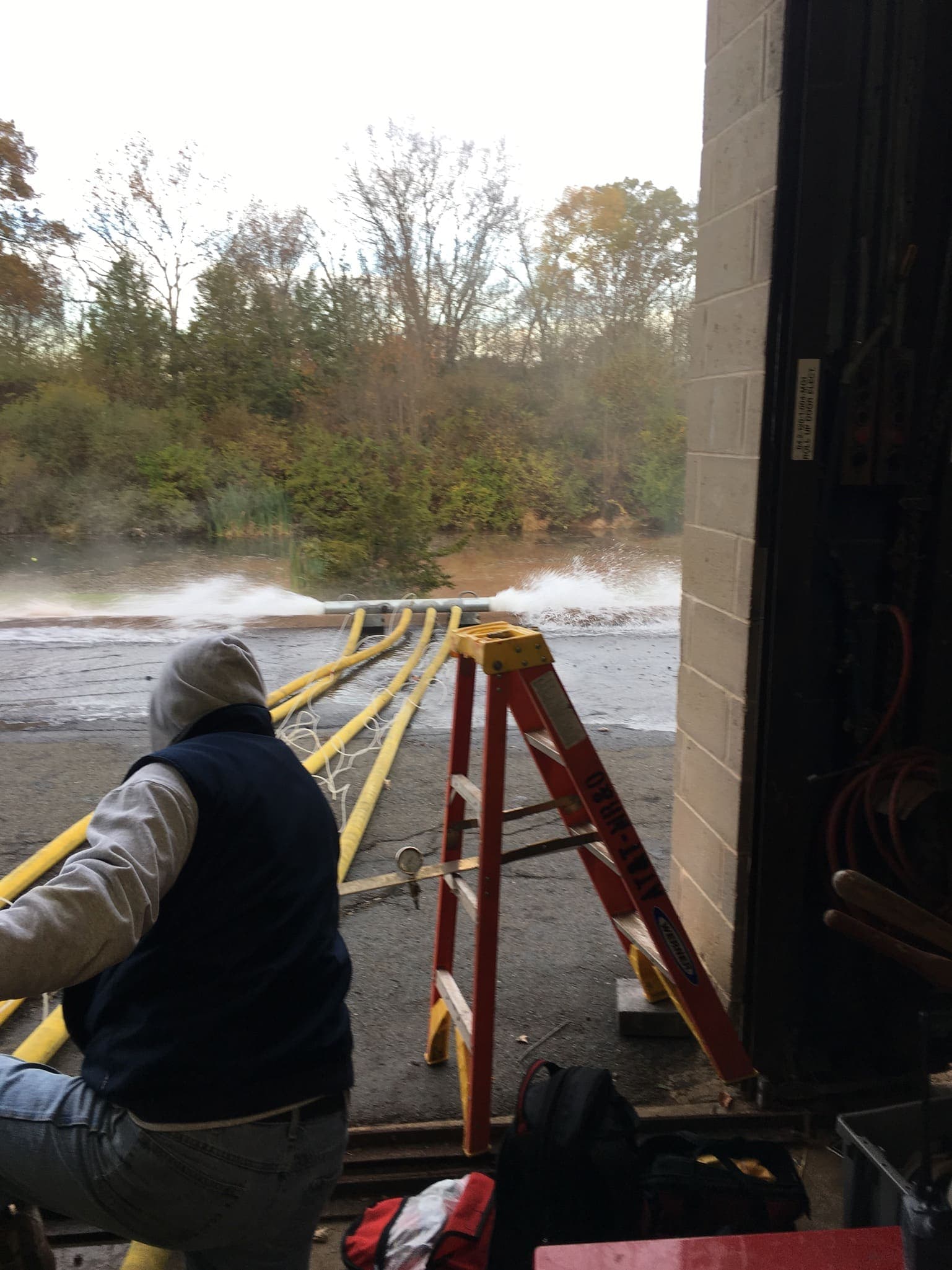 Technician running an outdoor flow test with water discharging at full flow